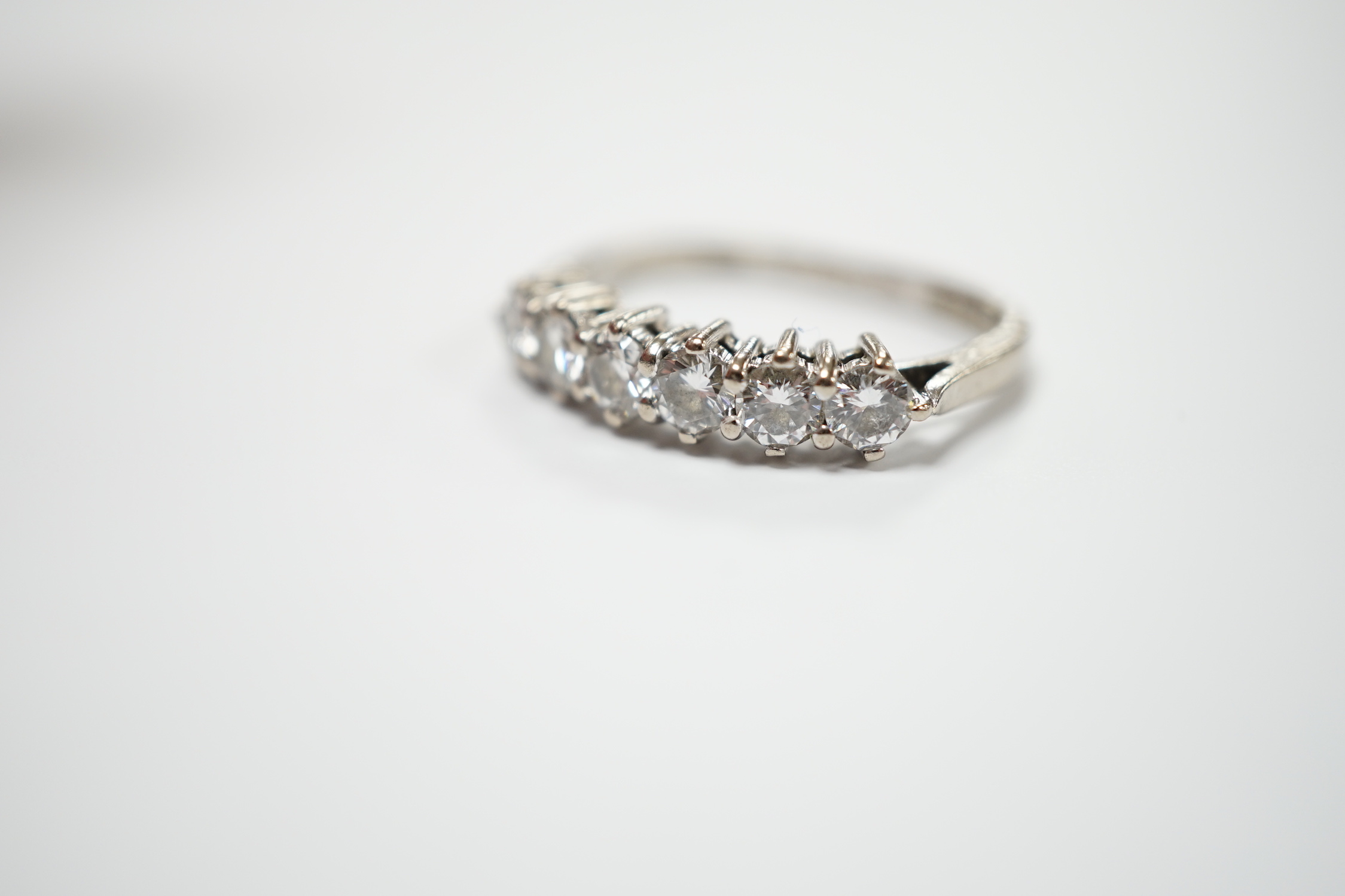 A modern 18ct white gold and six stone diamond set half hoop ring, (shank slightly crushed), gross weight 3.4 grams.